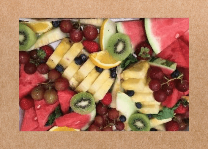 SOHO Coffee Co's fresh fruit platter box filled with kiwi, pineapple, watermelon, pineapple, grapes and strawberries.